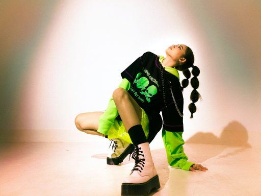 boy in black and green t-shirt and black pants sitting on floor