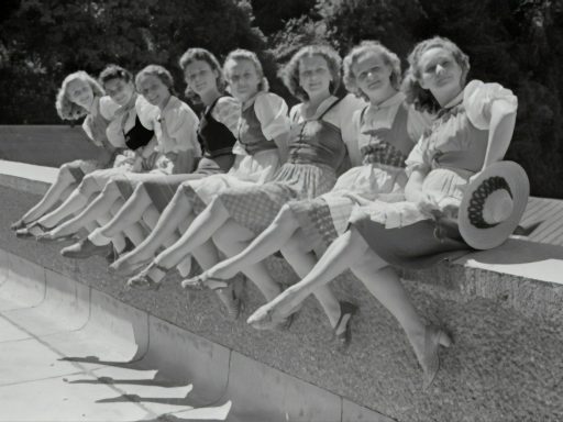 grayscale photo of group of women sitting on concrete bench