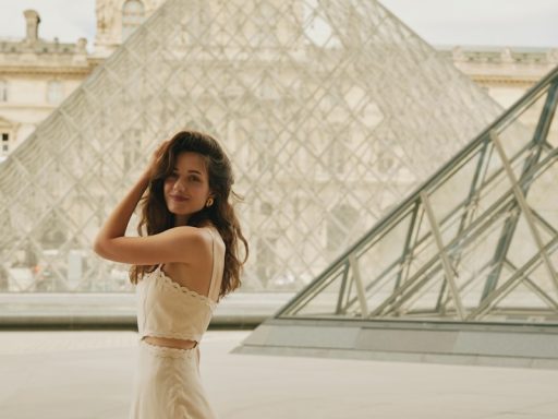 A woman in a dress standing in front of a pyramid