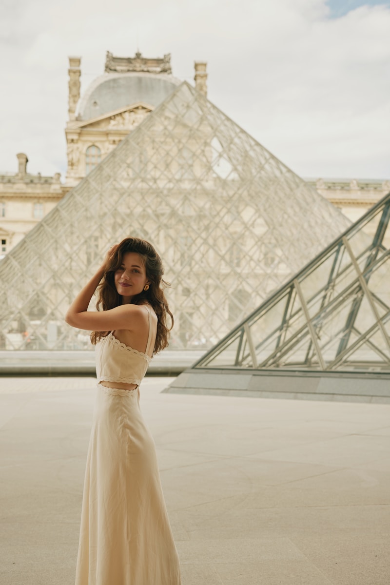 A woman in a dress standing in front of a pyramid