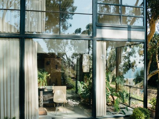 a glass walled patio with a table and chairs