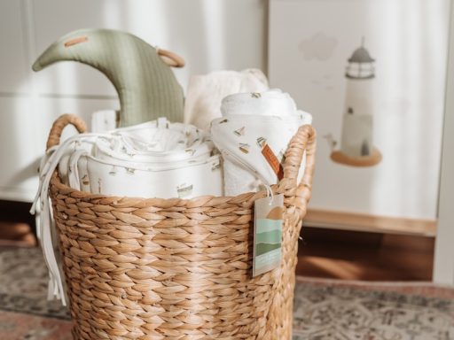 a wicker basket filled with blankets on top of a rug