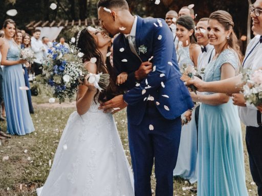 man in blue suit kissing woman in white wedding dress