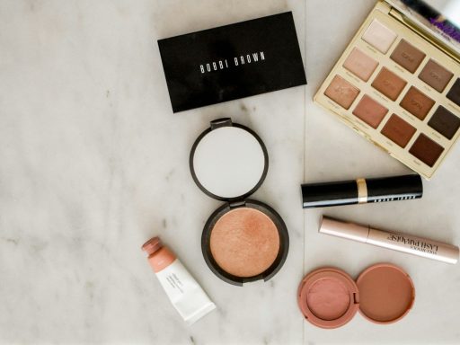 photo of assorted makeup products on gray surface