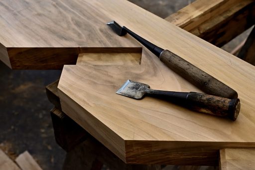 Meubelmaker die een houten kast opmeet in een werkplaats