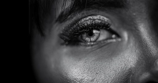 Vrouw die zichzelf bezorgd bekijkt in de spiegel en stresssignalen in haar huid herkent