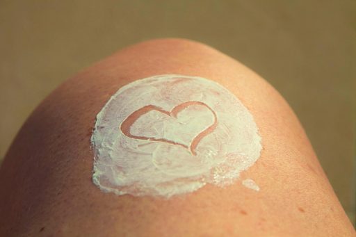 Vrouw die zonnebrandcrème aanbrengt op haar gezicht als onderdeel van haar huidverzorgingsroutine in de zomer