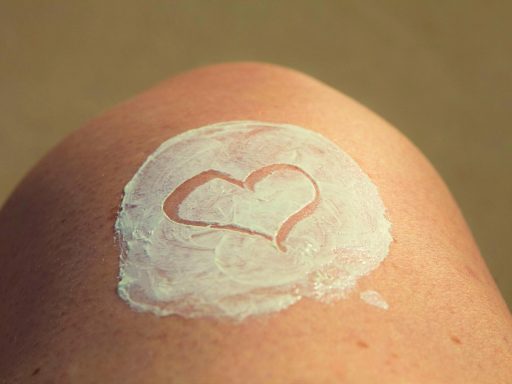 Vrouw die zonnebrandcrème aanbrengt op haar gezicht als onderdeel van haar huidverzorgingsroutine in de zomer