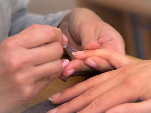 Kleurrijke zomerse nail art met botanische motieven en tropische kleuren op vrouwelijke handen