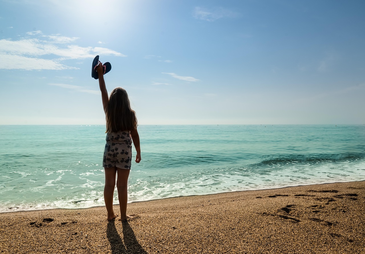 Vrouw op het strand met haar in de zon, zichtbaar droog en blootgesteld aan UV-straling