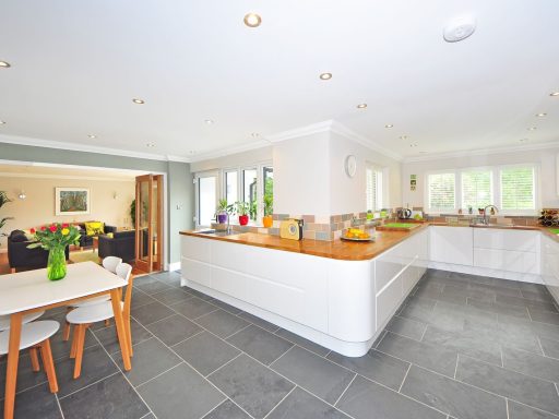 A spacious modern kitchen with elegant interiors featuring a dining table and luxurious design.
