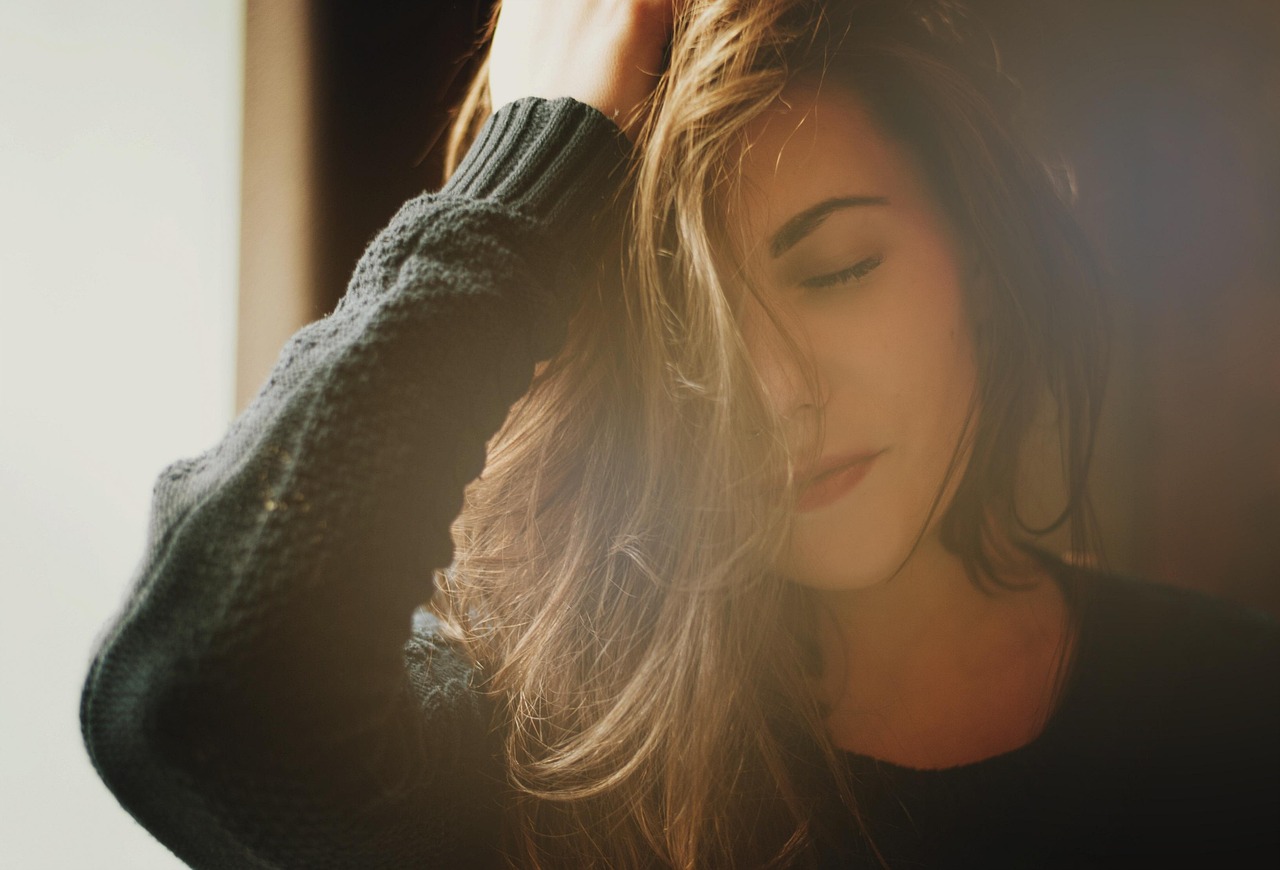 Vrouw met een natuurlijke, make-upvrije huid in het ochtendlicht