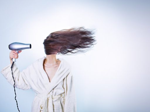 Vrouw die haar droge haar borstelt in een warme binnenruimte
