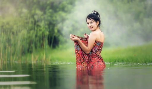 Vrouw die haar gezicht voorzichtig wast met water bij een wastafel