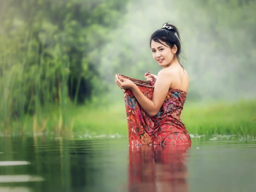Vrouw die haar gezicht voorzichtig wast met water bij een wastafel