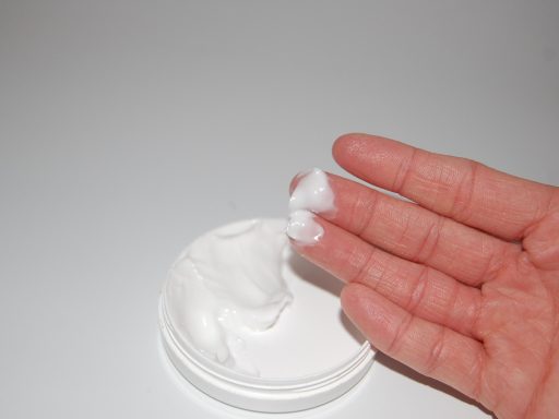 Vrouw die handcrème aanbrengt op droge, roodgekleurde handen