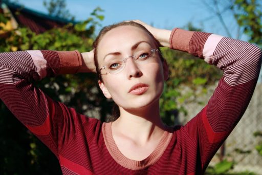 Vrouw met bril die oogmake-up aanbrengt voor een spiegel