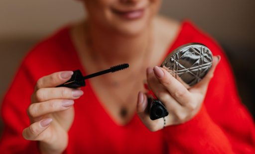 Vrouw die make-up aanbrengt voor de spiegel tijdens haar ochtendroutine