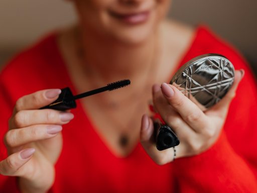Vrouw die make-up aanbrengt voor de spiegel tijdens haar ochtendroutine
