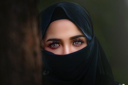 Vrouw die zichzelf in de spiegel bekijkt en wallen onder haar ogen bestudeert